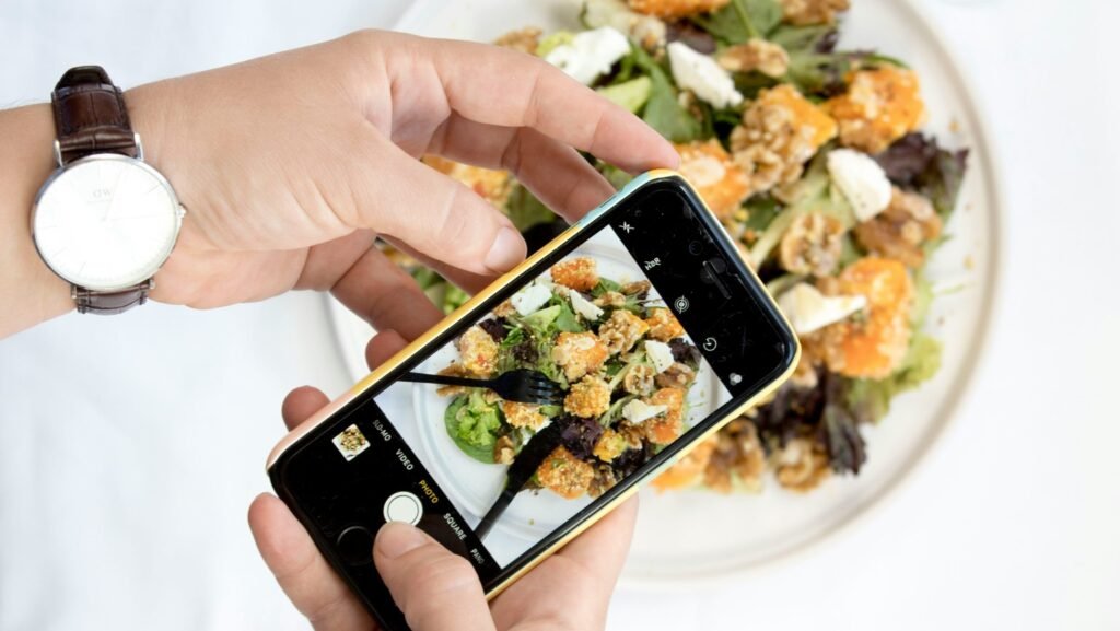 person using iPhone taking picture of food
